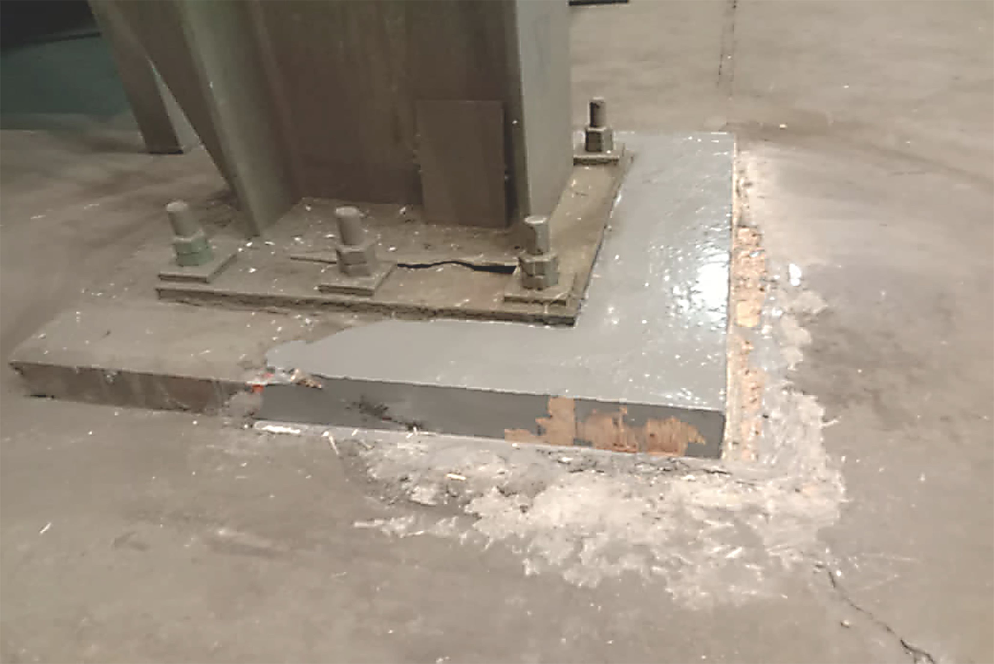 Base de machine industrielle avec des fondations en béton réparées et scellées d'une couche grise