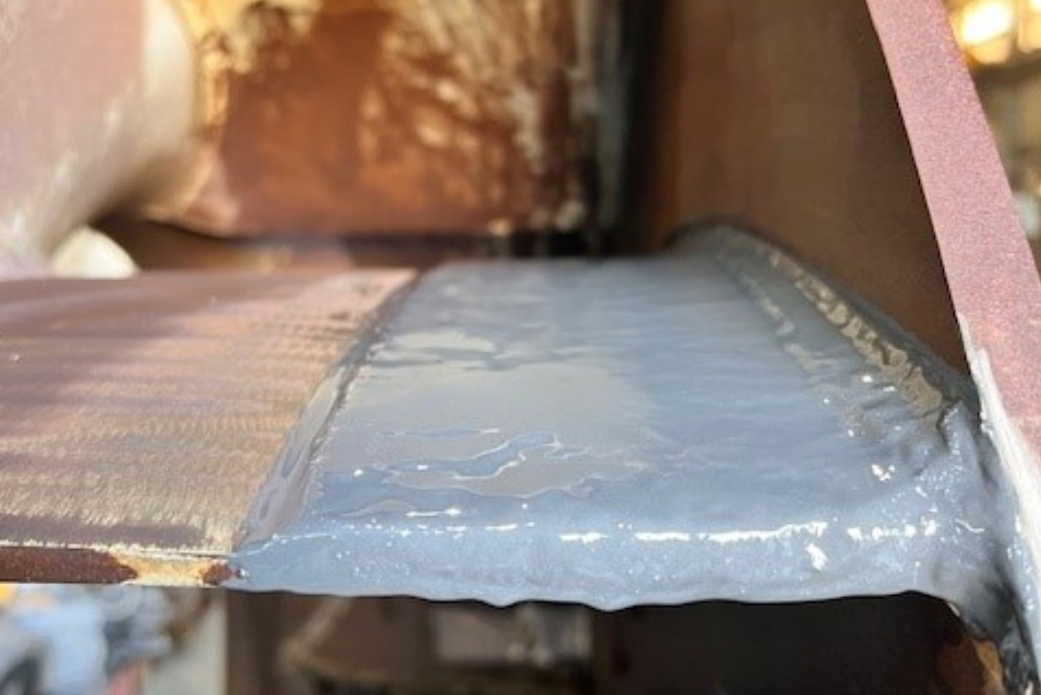 Composant métallique industriel avec une protection de surface grise appliquée sur une section structurelle soudée.