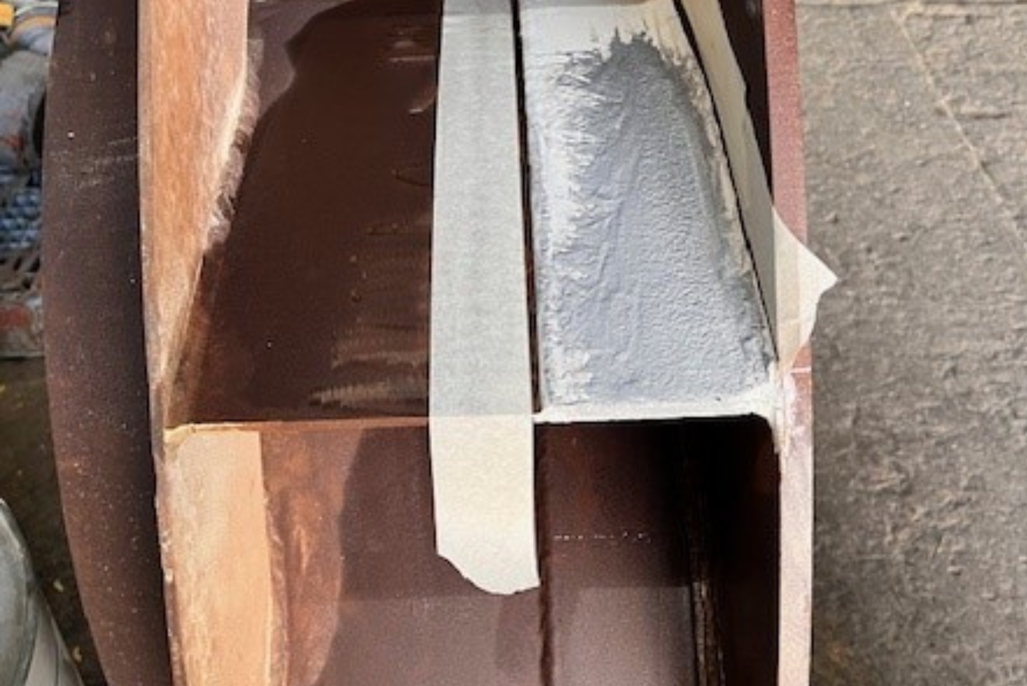 Application de ruban de masquage sur une structure métallique industrielle pour délimiter avec précision la zone à traiter par un revêtement de protection gris
